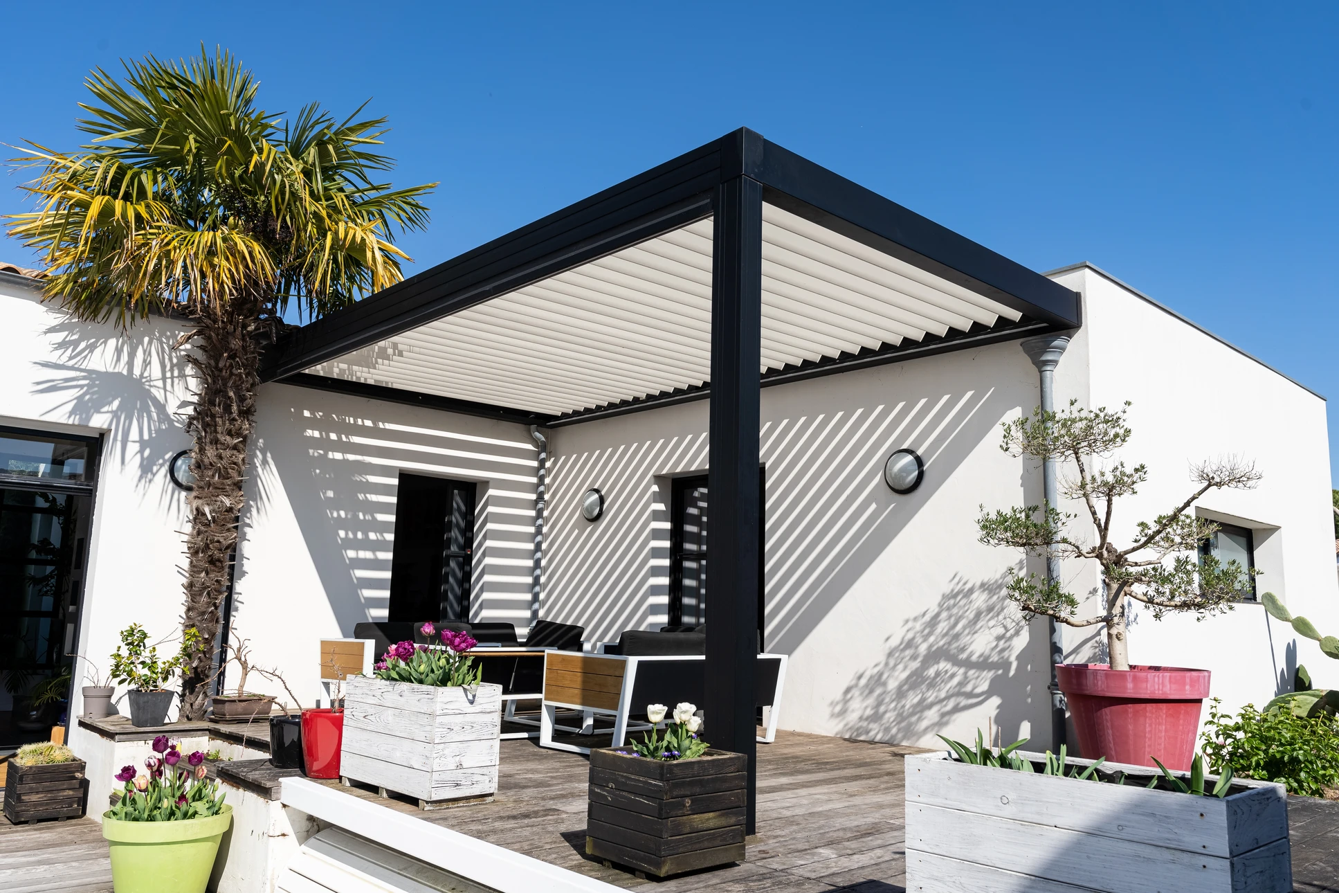 Terrasse extérieure couverte d'une pergola en bois avec salon de jardin contemporain